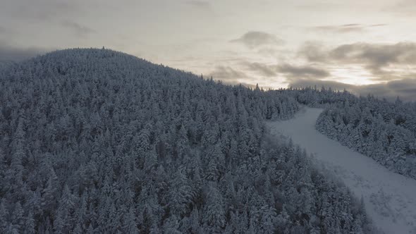 Abandonded ski trail at the peak of a snow covered mountain SLOW AERIAL ORBIT