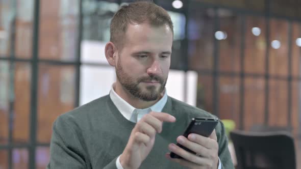 Portrait Shoot of Young Man Using Cellphone and Celebrating