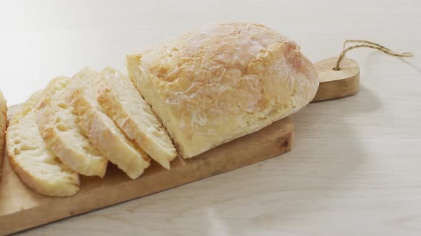 Video of bread on wooden chopping board seeing from above