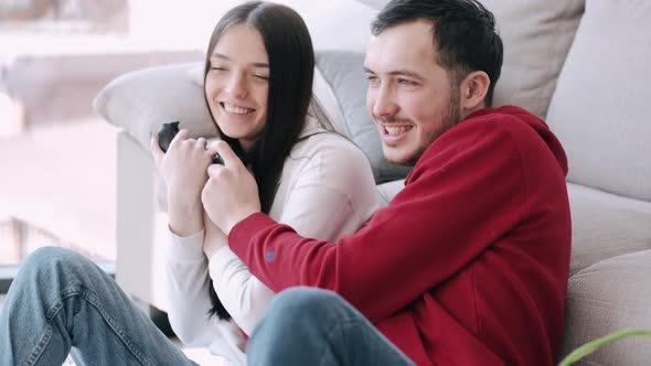 A Pretty Girl and a Boy Are Playing Video Games in the Living Room