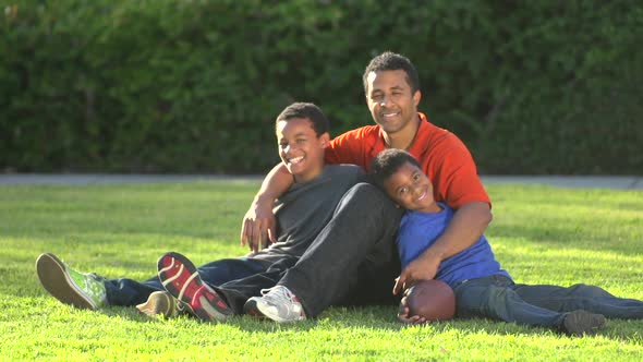 Group portrait of a father and his sons with a football.