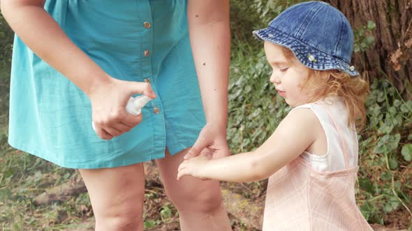 Mother Treats the Child with a Spray for Mosquitoes Insects Ticks Fleas