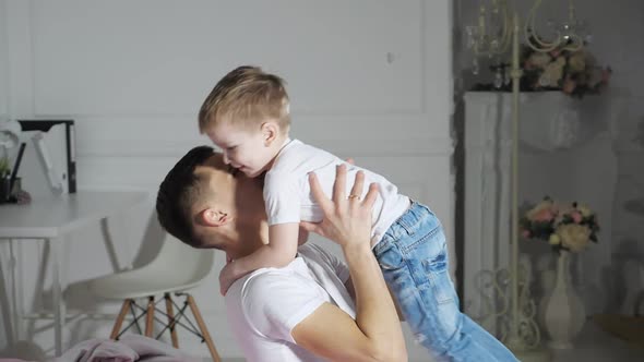 Dad and Son are Hugging Falling in Bed Together Slow Motion