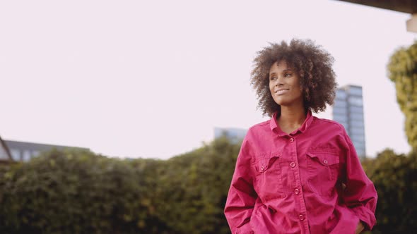 Smiling Young Woman With Afro Hair In Bright Pink Fashion