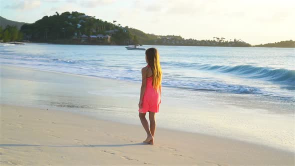 Adorable Happy Little Girl Walking on White Beach at Sunset, SLOW MOTION VIDEO