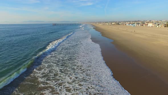 Aerial shot of a scenic beach shoreline at sunset.