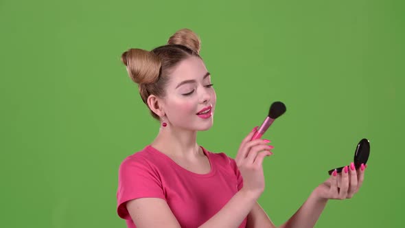 Girl Holding a Brush in Her Hand and Powdering Her Face, Green Screen