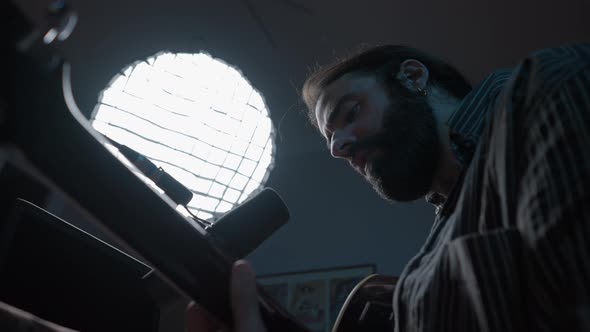 Bearded Caucasian Guitarist Playing Some Intense Song in His Home