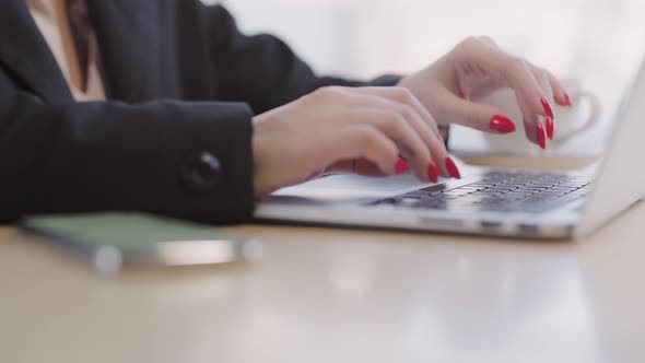 In the Frame a Laptop Keyboard and Female Hands with a Highquality Manicure