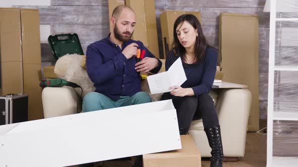 Young Couple Assembling a Shelf As a Team