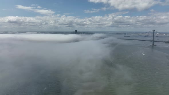An aerial view of Gravesend Bay in Brooklyn, NY on a cloudy day. There is a low dense fog over the w