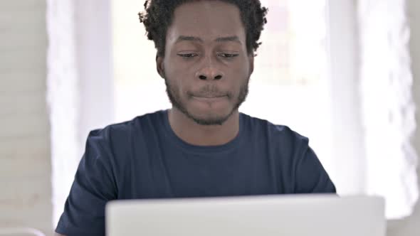 Young African Man Drinking Coffee at Work