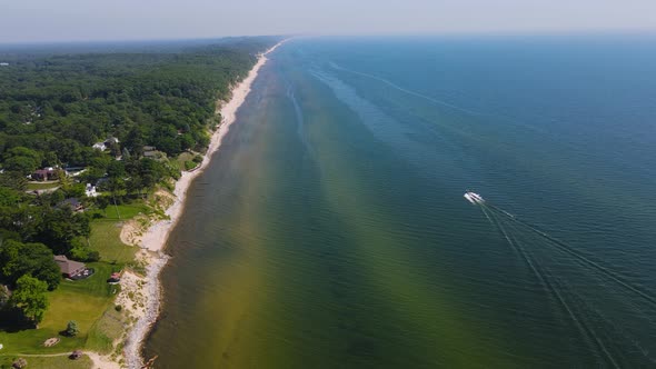 Boat sailing parallels to the Coast of Lake Michigan in the heat of Summer Near Muskegon, MI.