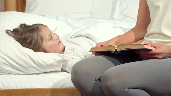 Lovely Little Girl Laughing in Her Bed Her Mother Reading Her a Book Before Sleep