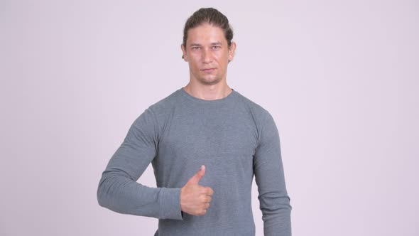 Handsome Man Giving Thumbs Up Against White Background