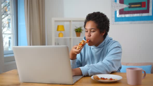 African Woman Working From Home and Eating Delivery Pizza