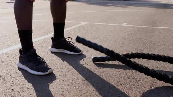 African American man working out with battle ropes