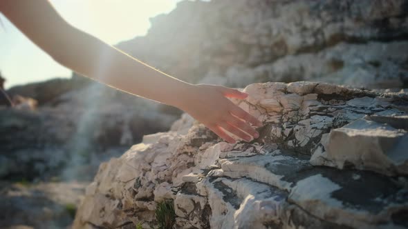 Girl Walking on the Coast and Touching Rocks