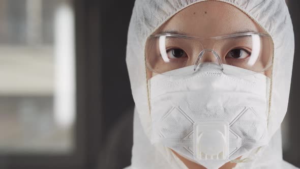 Asian Woman in Protective Mask and Glasses Looking at the Camera Chinese Coronavirus Quarantine Zone