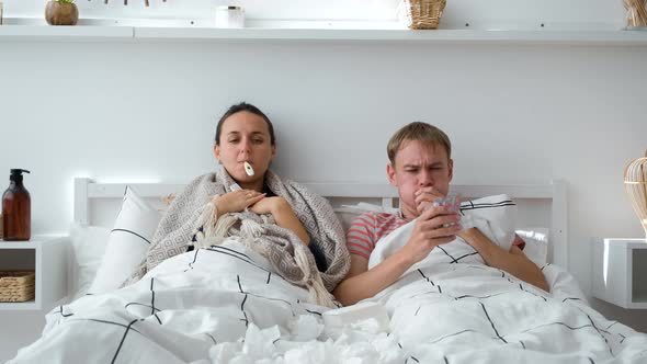 Couple Lying in Bed with High Fever and Flu