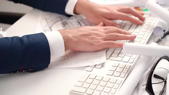 Engineer using keyboard between projects in office.