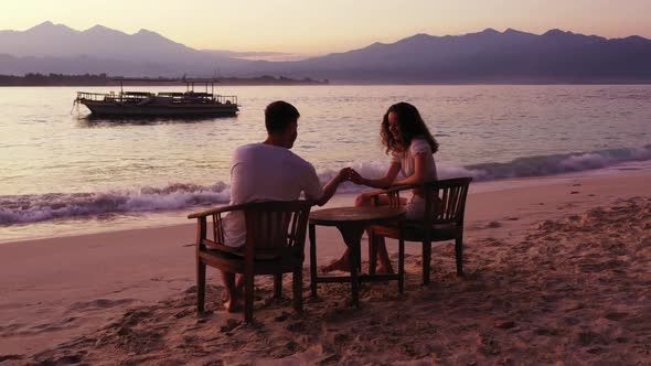 Man and woman in love on marine seashore beach adventure by blue ocean and white sand background of 