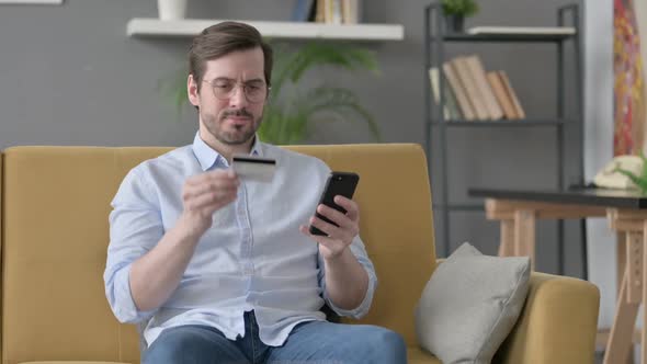 Young Man Making Online Payment on Smartphone