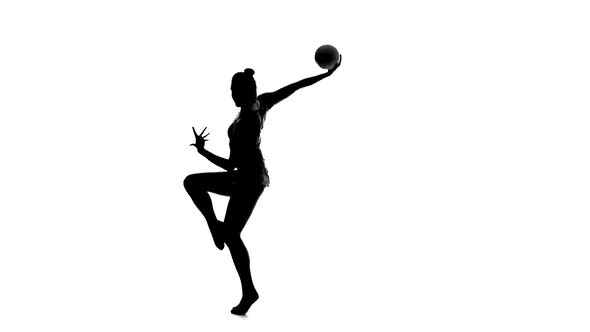 Gymnast To Be Turned with the Ball in His Hands. White Background. Silhouette. Slow Motion