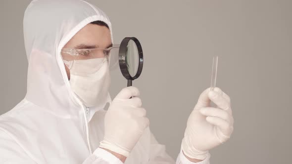 Male Researcher in Full-covering Equipment Is Examining a Microscope Glass in a Laboratory