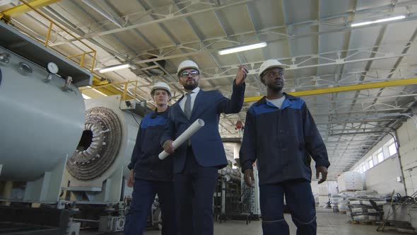  Manufacturing Engineer and Workers Walking in Factory