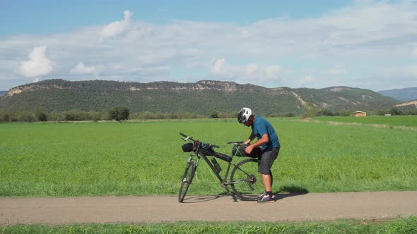 Adventurous Man with a Bicycle Applying a Backpack