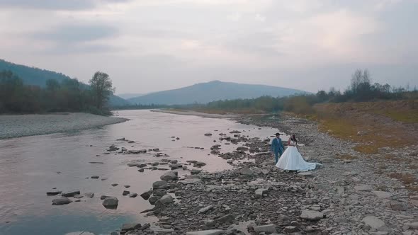 Wedding Couple Stand Near Mountain River