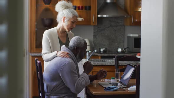 Sick mixed race senior couple having a video call on laptop at home