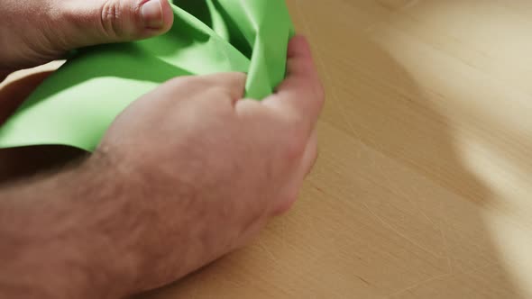 Hands Crumpling Green Paper Closeup