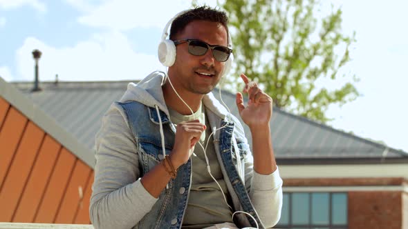 Man with Smartphone and Headphones on Roof Top