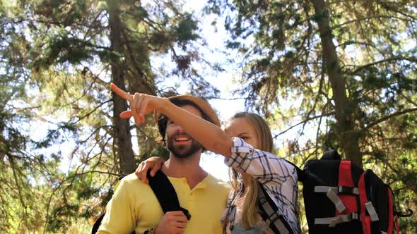 Hiker couple standing and pointing away in forest