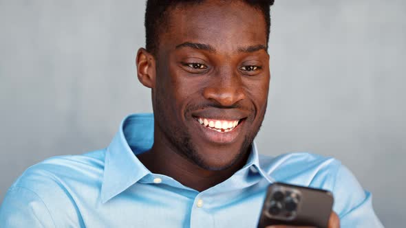 Smiling young student sending a message using a smartphone