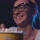 Woman watching a comedy movie at the cinema and eating popcorn - VideoHive Item for Sale