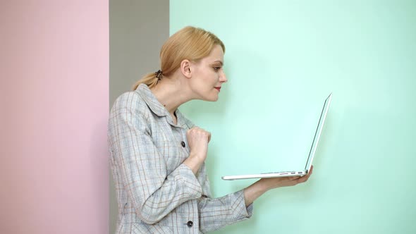 Young Woman with Notebook. Blonde Girl in Casual Clothes Posing on Color Studio Background. People