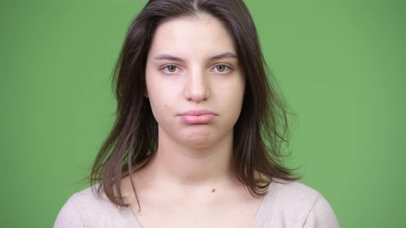 Young Beautiful Woman Looking Bored Against Green Background