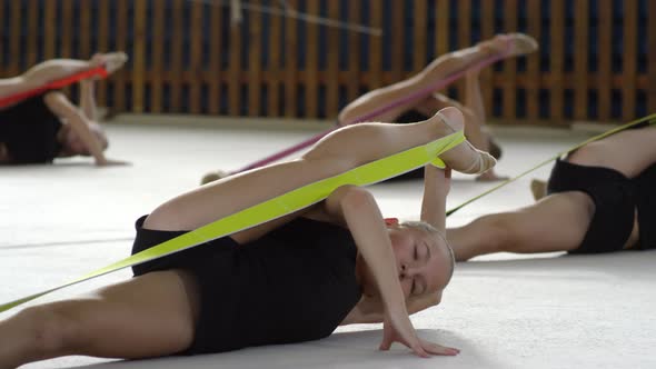 Girls Stretching Legs in Gymnastics Class