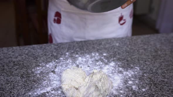 Pastry chef taking mixed dough ingredients out of bowl ready for kneading