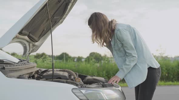 Woman Standing Near the Broken Car. The Girl Opened the Hood and Look at the Engine. 