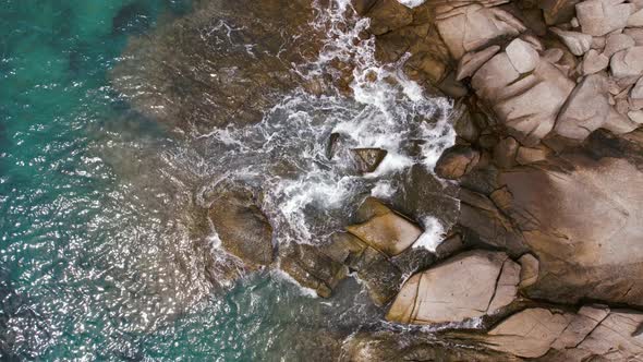 Aerial Top View  Footage By Drone of Ocean Blue Waves Break on High Cliff of a Rocky Mountain