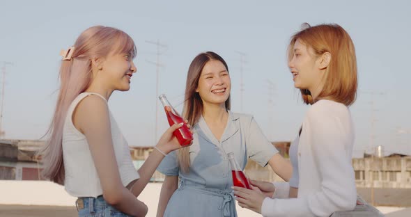 Group of Young pretty Asian girlfriends enjoying with drinking alcohol at rooftop together.