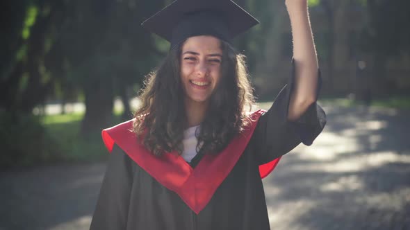 Medium Shot Portrait of Happy Smiling Caucasian Graduate Woman Posing with Diploma in Sunshine