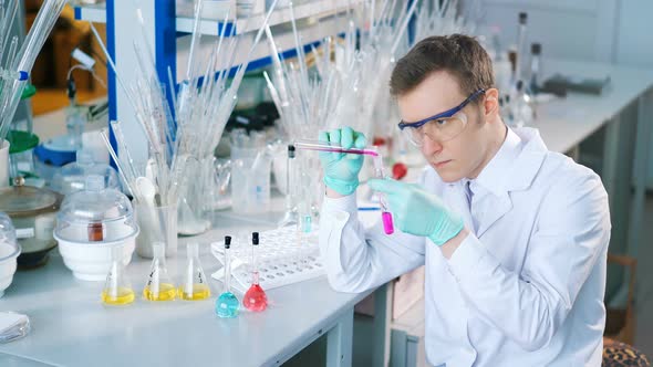 A Young Man Doing an Experiment in a Chemical Laboratory