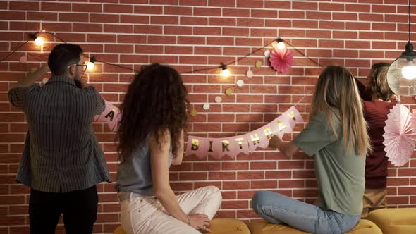 Friends Preparing Party Indoors Hanging Garlands and Hbirthday Letters