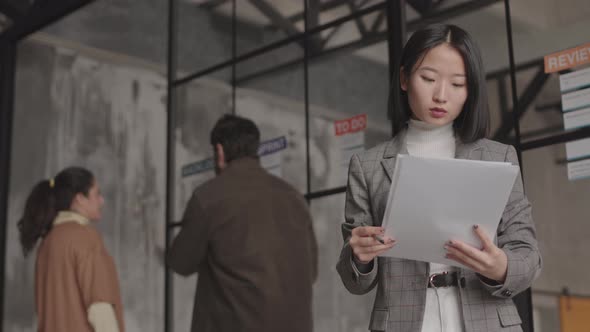 Asian Businesswoman Posing with Papers