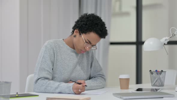 African Woman Unable To Write on Paper at Work 